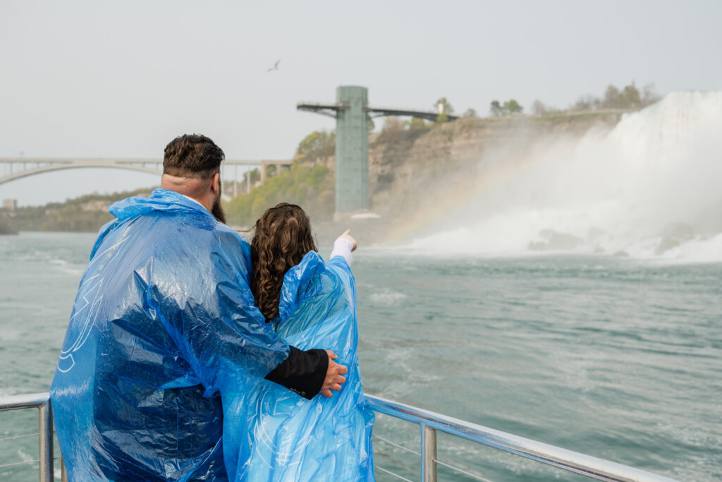 couple on maid of the mist looking at niagara falls
