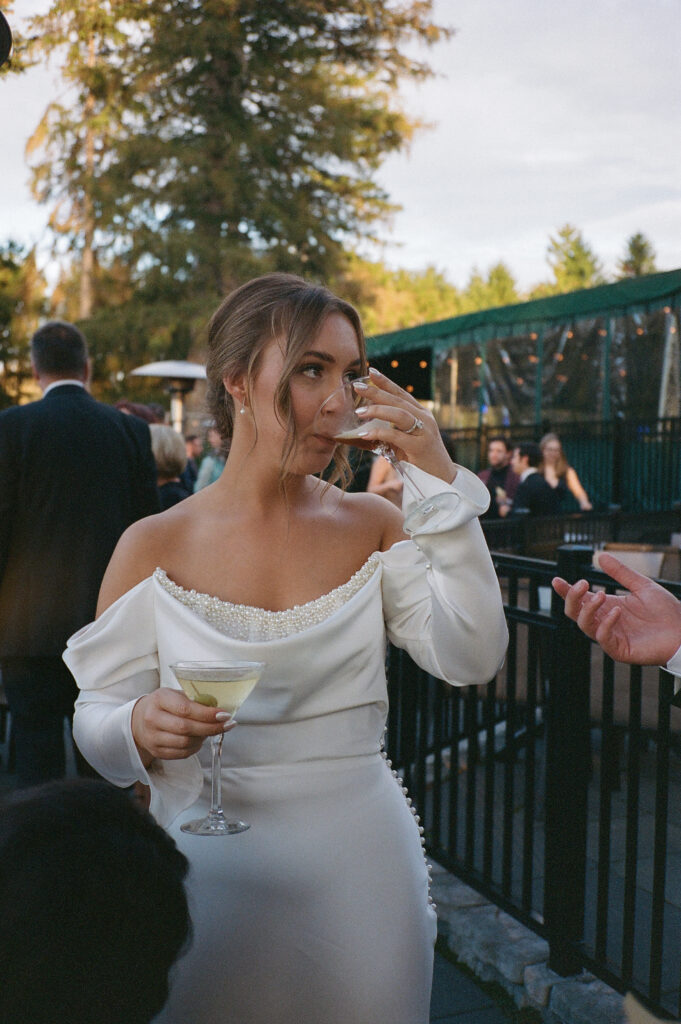 A wedding photo captured on 35mm film featuring a bride drinking an espresso martini