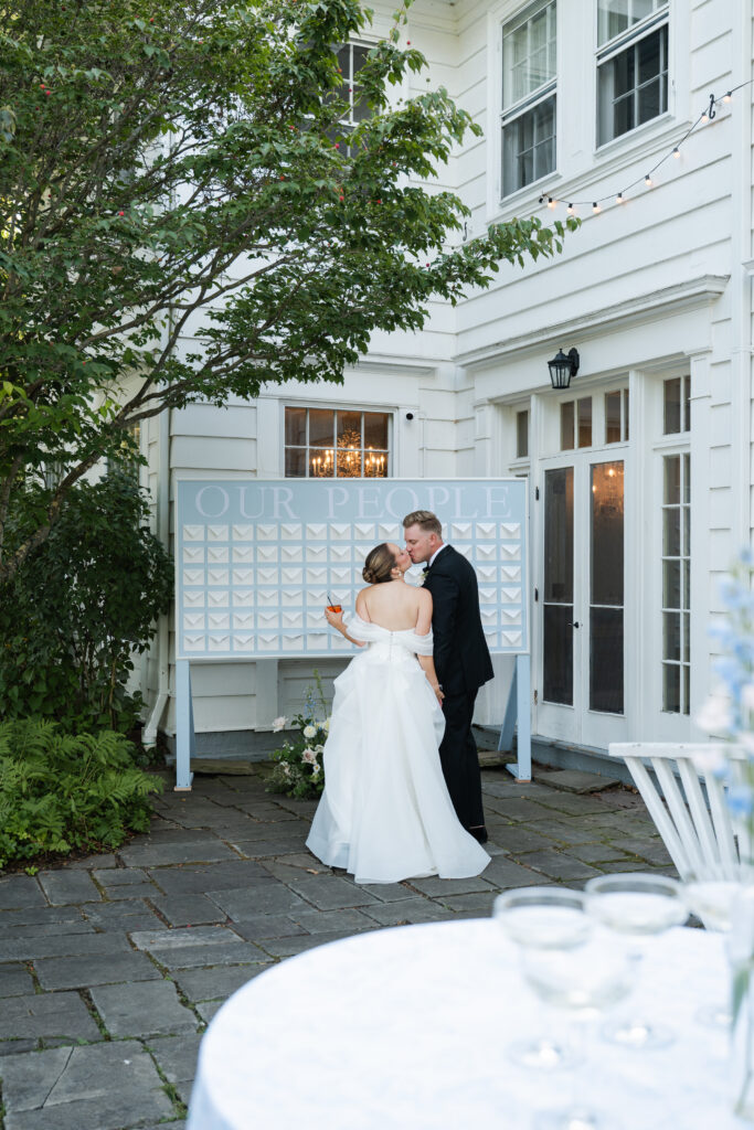 Bride and Groom stand in front of their personalized guest notes displayed as seating chart during Knox Farm wedding reception.