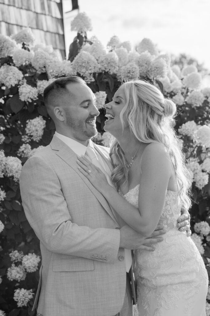 Documentary-style candid of bride and groom embracing under soft summer light