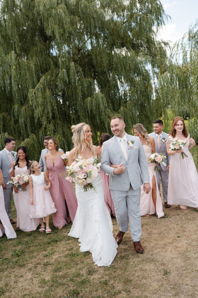 Bride and groom walking under the willow trees at The Sterling at Arrowhead