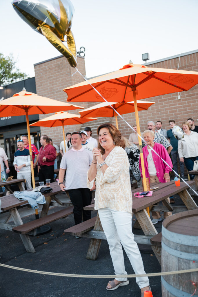 family surprised couple after their proposal at a local bar