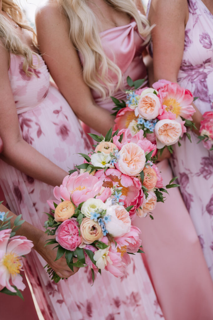 pink mismatched bridesmaids dresses with pink summery floral bouquets
