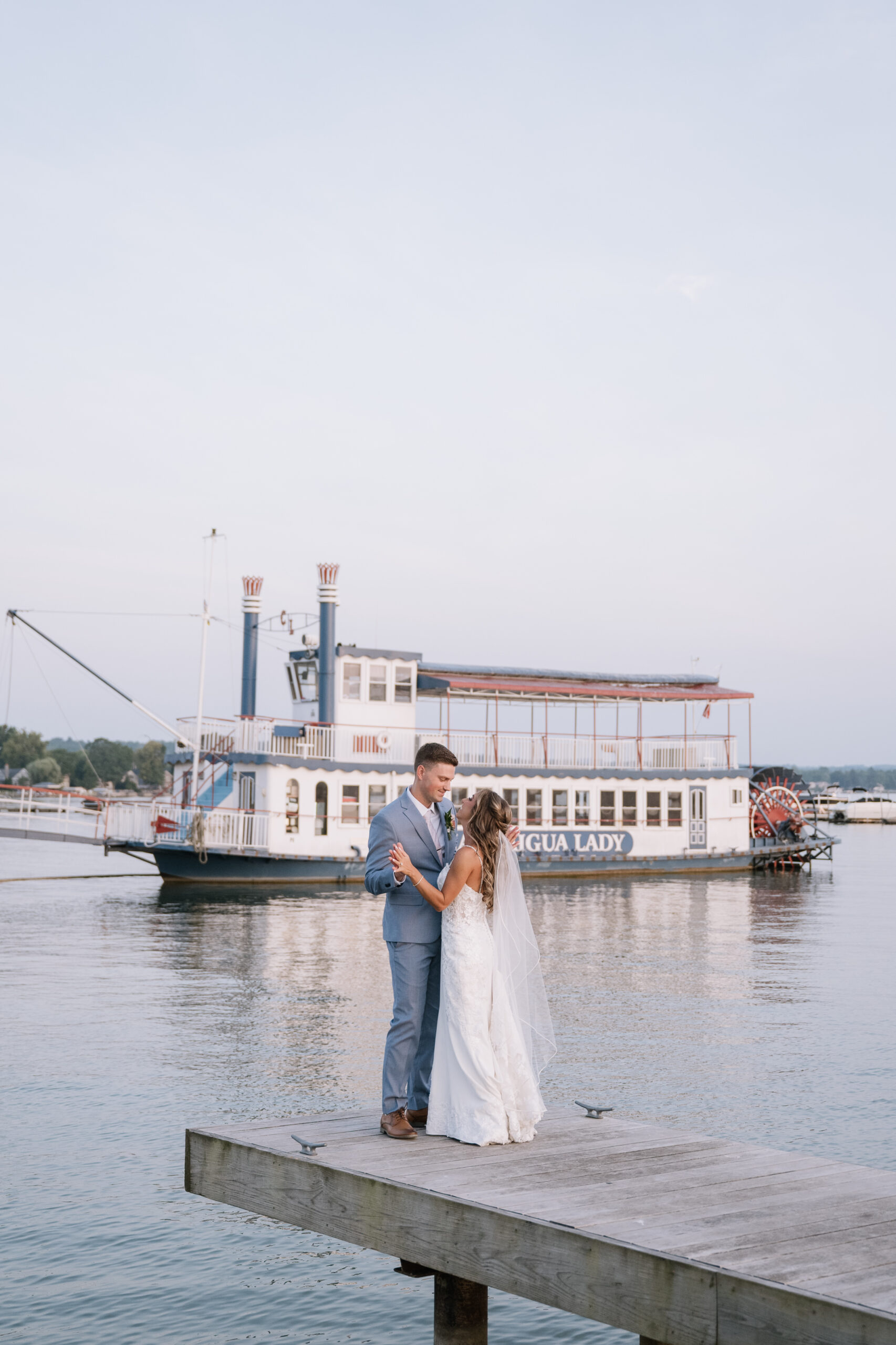 bride and groom portraits on canandaigua lake dock during sunset