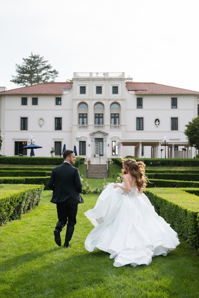 Bride and groom walking through the gardens at Geneva On the Lake in Geneva NY